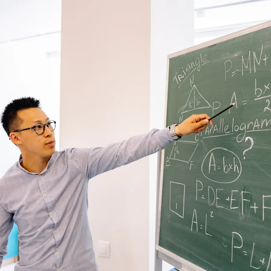 An instructor points out a geometry formula on a chalkboard.