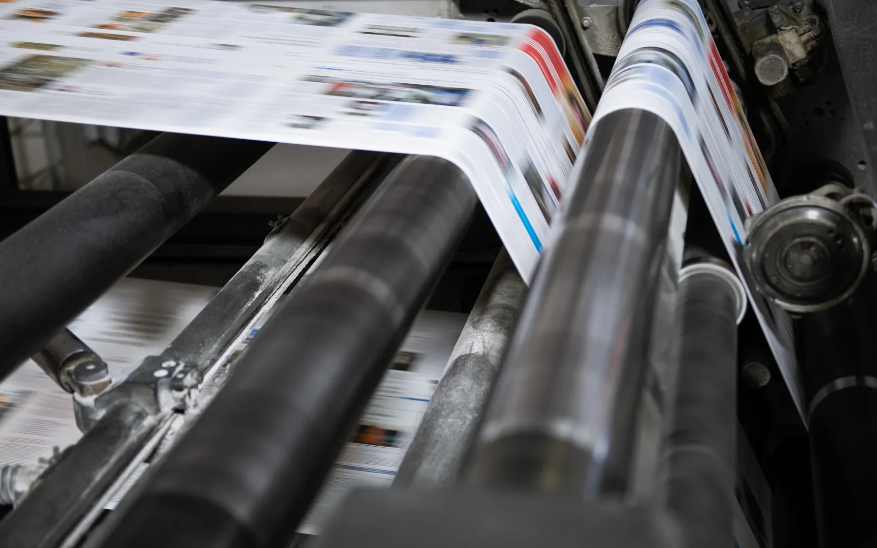 Freshly printed color pages run through a web press.